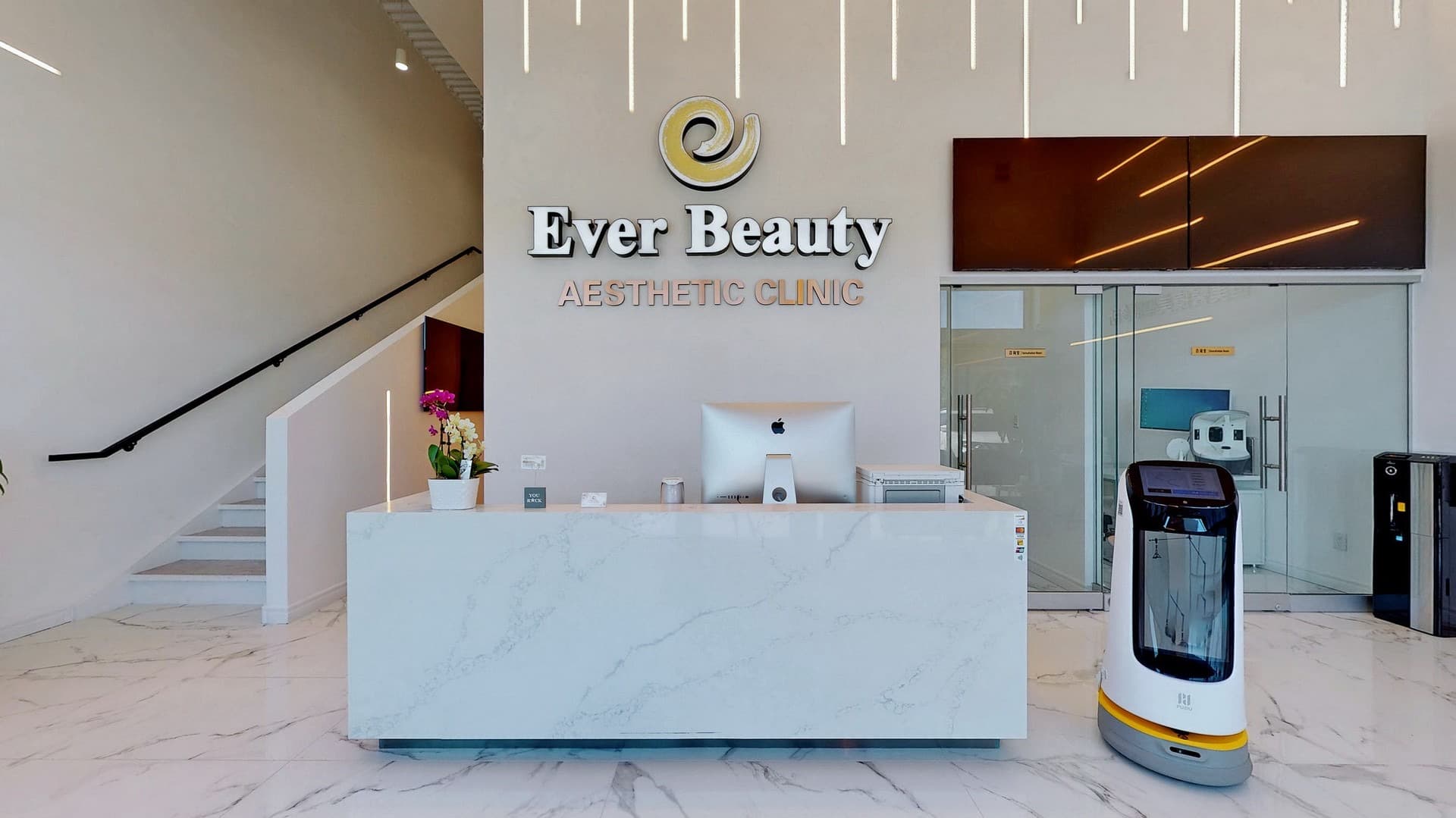Modern marble reception desk at Ever Beauty Aesthetic Clinic with a white service robot.